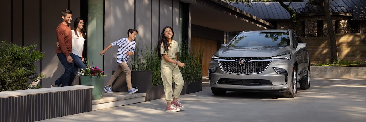 Scenic view of the 2024 Buick Enclave in front of a family home.