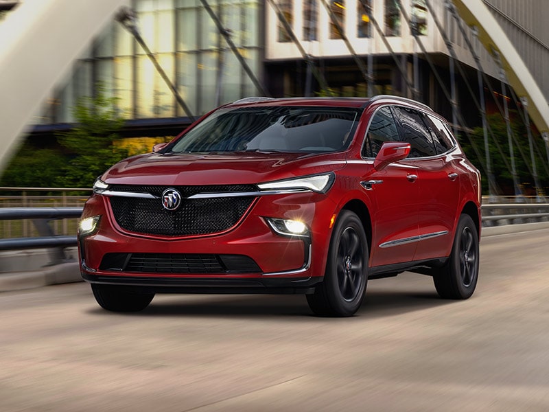 2024 Buick Enclave Sport Touring driving with its headlamps on.