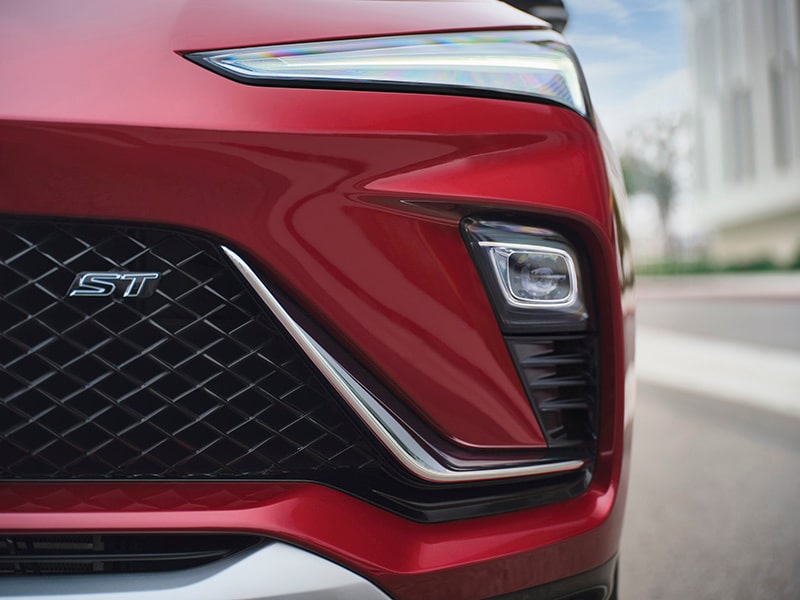 Sport Touring insignia and front headlight close-up of the 2024 Buick Envista ST.