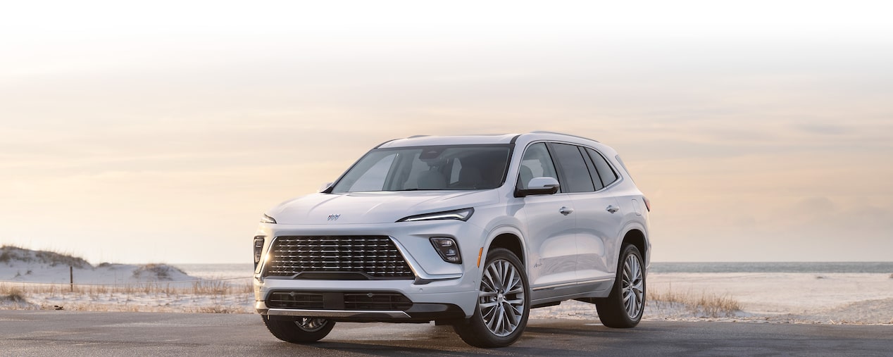 Front-side view of the 2025 Buick Enclave parked by the beach.