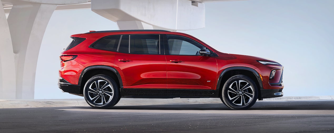 Side view of the 2025 Buick Enclave parked near a bridge.