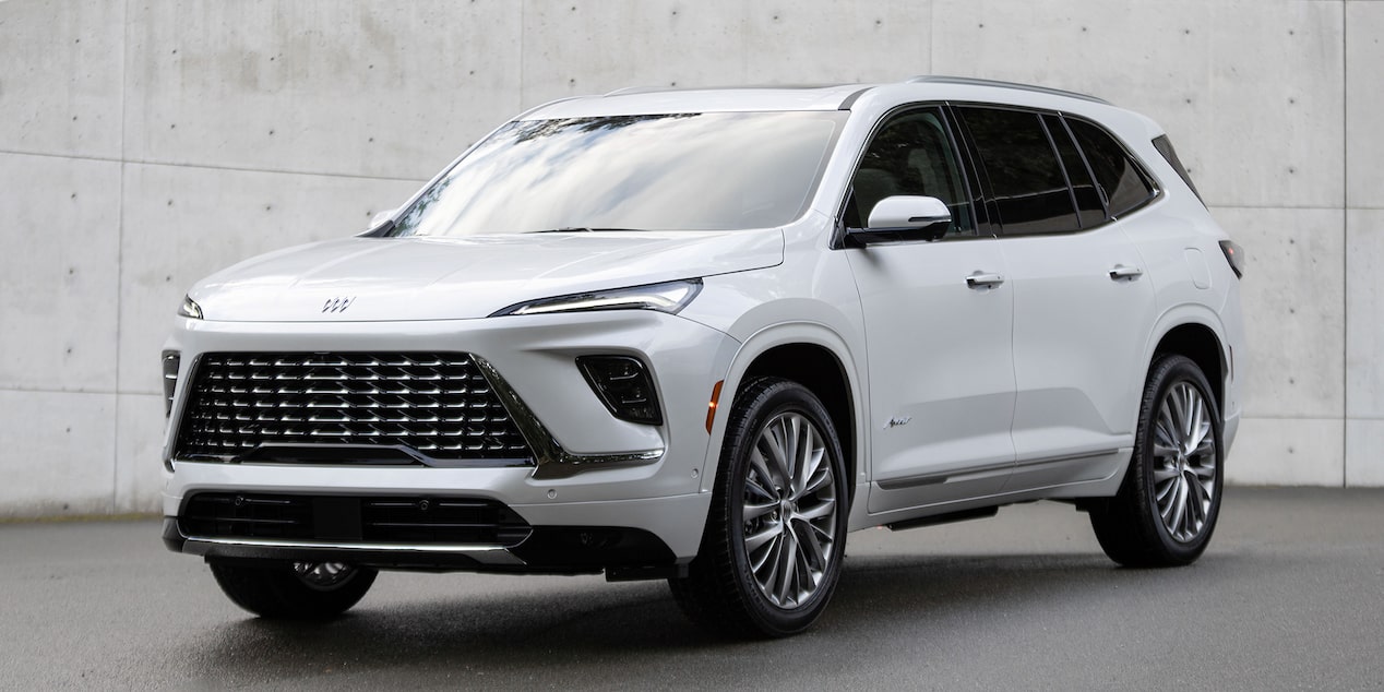 Front-side view of the 2025 Buick Enclave Avenir parked near a wall.