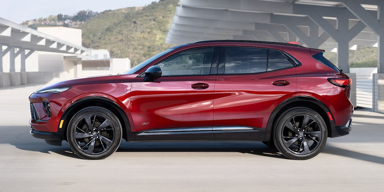 Vue latérale du VUS compact Buick Envision ST 2025 stationné dans un parc de stationnement vide.