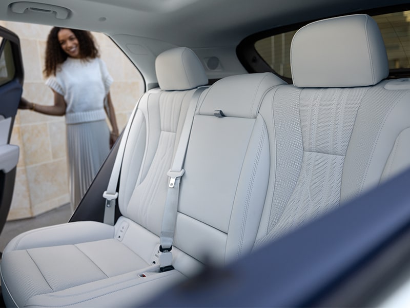 Une femme regarde les sièges arrière du VUS compact de luxe Buick Envision Avenir 2025.