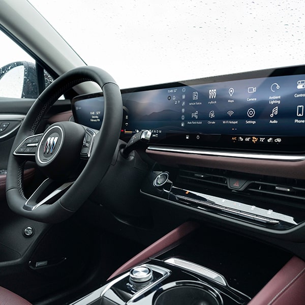 Close-up Interior View of the Steering Wheel and Infotainment System in a 2025 Buick Envision Avenir Compact Luxury SUV.