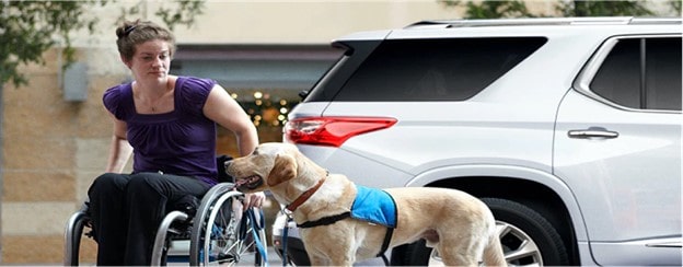 A man carrying a wheelchair for someone eligible for GM’s Mobility Program.