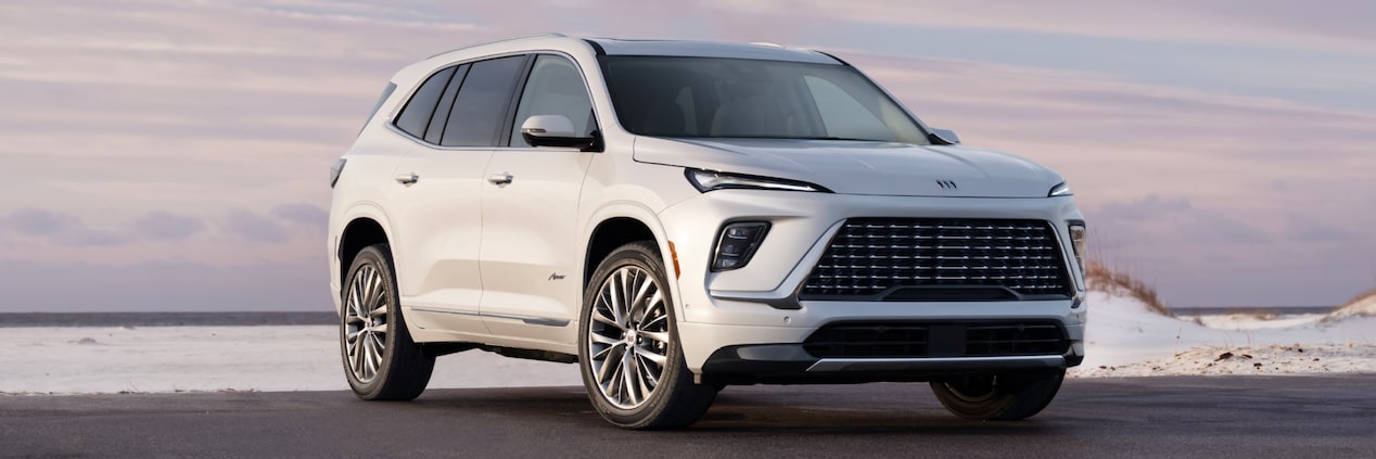 Front-side view of the 2025 Buick Enclave Avenir parked alone by the beachside.