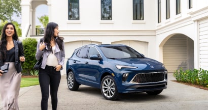 Deux personnes passant devant un véhicule Buick pour les programmes de rabais GM.